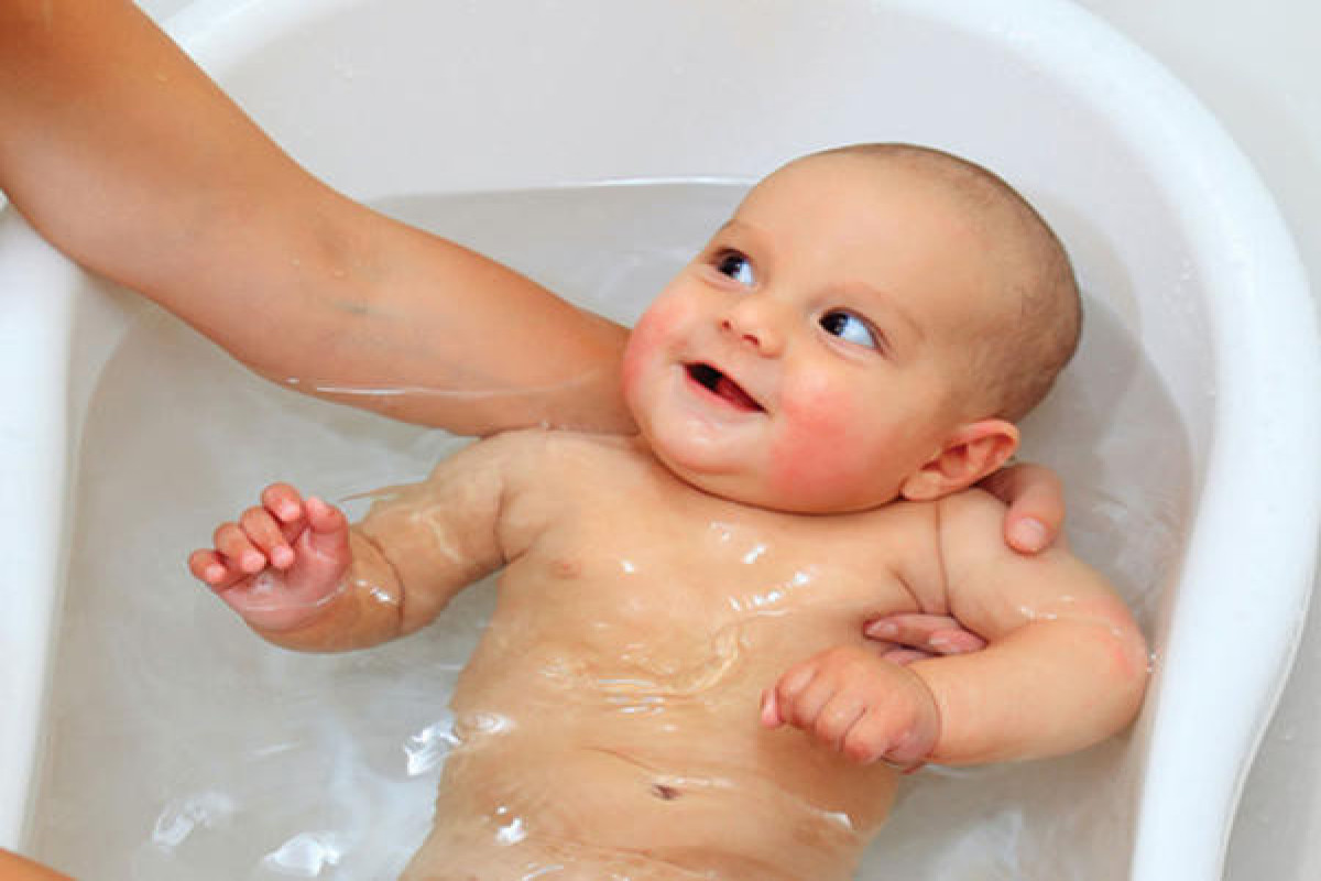 Первая гигиеническая ванна. Купание новорожденного ребенка. Гигиенические ванны для новорожденных. Купание малыша в ванночке. Малыш купается.